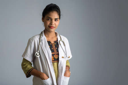 Woman doctor with a stethoscope on grey backgroundの写真素材