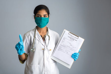 Coronavirus concept for a blood test. A young woman doctor reading or filling a medical test form...