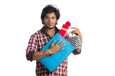 Young men showing rakhi on his hand with shopping bags and gift box on the occasion of Raksha...