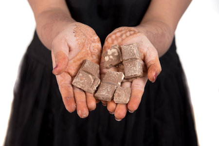 Portrait of a happy young woman eating chocolate bar isolated over white background