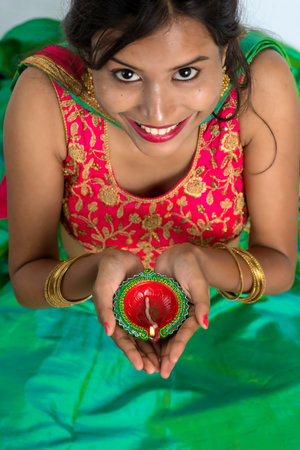 Portrait of a Indian Traditional Girl holding Diya, Girl Celebrating Diwali or Deepavali with...