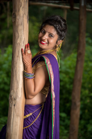 Beautiful Indian young girl in Traditional Saree posing outdoors