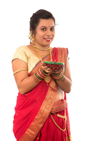 Portrait of a Indian Traditional Girl holding pooja thali with diya during festival of light on...