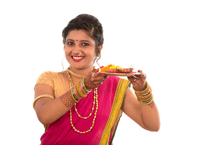 Portrait of a Indian Traditional Girl holding pooja thali with diya during festival of light on...