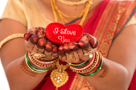 Traditional Beautiful Indian young girl in saree posing with Heart on white backgroundの写真素材