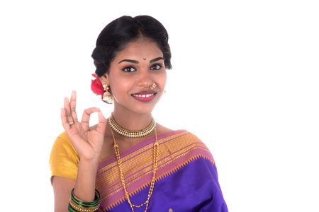 Beautiful Indian young girl posing in traditional Indian saree on white background.