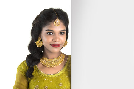 Traditional Girl holding and showing blank white sign boardの写真素材