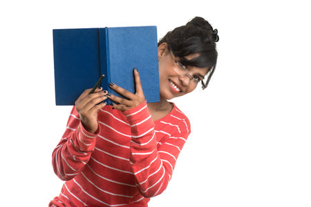 Pretty young girl holding book and posing on white background