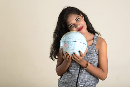 Portrait of young Girl holding and posing with a world globe.