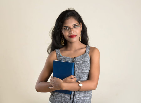 Pretty young girl holding and posing with book