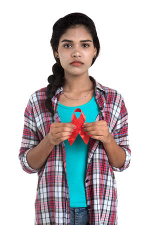 Young woman showing red ribbon HIV, AIDS awareness ribbon, healthcare and medicine conceptの写真素材