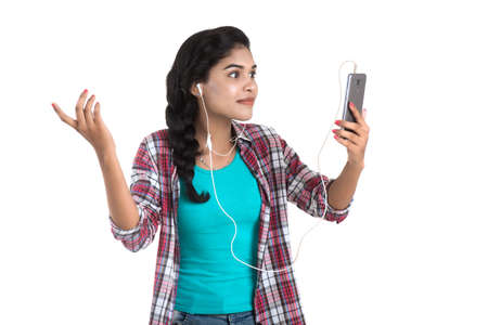 Young Indian girl using a mobile phone or smartphone isolated on a white backgroundの写真素材