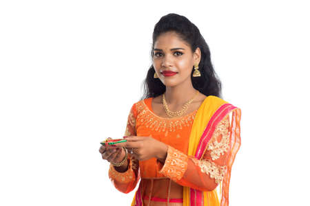 Portrait of a Indian Traditional Girl holding Diya, Girl Celebrating Diwali or Deepavali with holding oil lamp during festival of light on white backgroundの写真素材