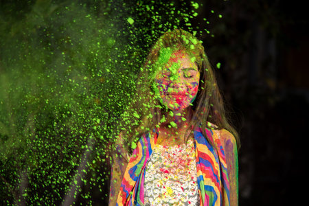 A young girl plays with colors. The concept for Indian festival Holi. color splash.の写真素材