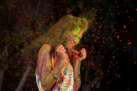 A young girl plays with colors. The concept for Indian festival Holi. color splash.の写真素材