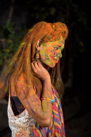 A young girl plays with colors. The concept for Indian festival Holi. color splash.の写真素材