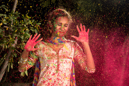 Young girl plays with colors on the occasion of Holi. Concept for Indian festival Holi. color splash.の写真素材