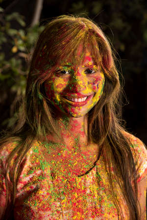Portrait of a happy young girl on the festival of colors Holi. Girl posing and celebrating the festival of colors.の写真素材
