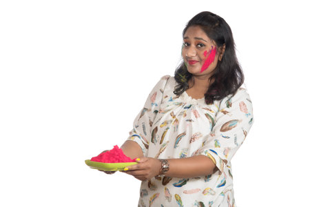 Beautiful young girl holding powdered color in plate on the occasion of Holi festival.の写真素材
