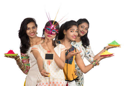 Group of happy young girls having fun with colorful powder at Holi festival of colorsの写真素材