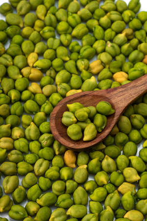 Fresh green Chickpea (Cicer arietinum) in wooden spoon with scattered chickpeas on a white background. Desi variety.の写真素材