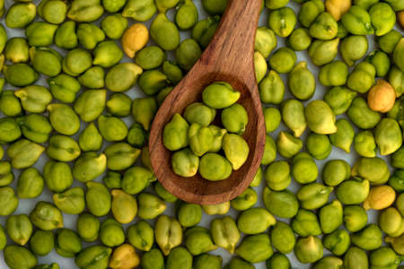 Fresh green Chickpea (Cicer arietinum) in wooden spoon with scattered chickpeas on a white background. Desi variety.の写真素材