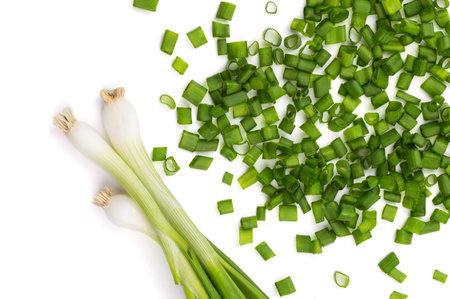 Fresh ripe green spring onions (shallots or scallions) with fresh chopped green onions on white...
