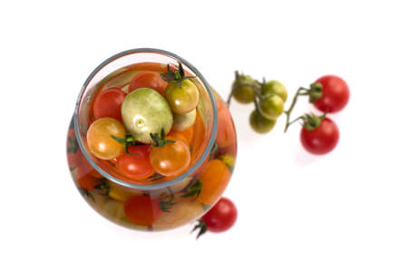 Fresh cherry tomato in glass jar with tomatoes on branch isolated on white background.の写真素材