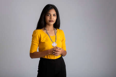 Portrait of a young girl posing on gray backgroundの写真素材