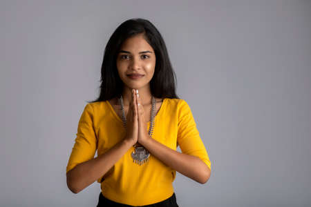 Beautiful Indian girl with welcome expression or inviting or greeting Namasteの写真素材