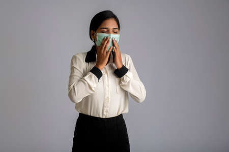 woman wearing a medical mask feeling sick or ill, having a fever.の写真素材