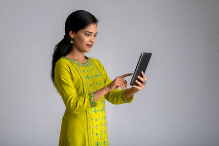 Young girl using mobile phone or smartphone on gray backgroundの写真素材