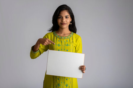 A young girl or businesswoman holding a signboard in her hands on a gray background.