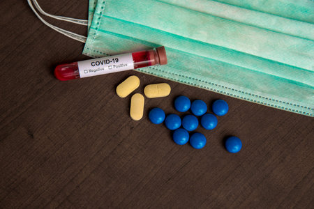 Tube containing a blood sample for testing to the presence of coronavirus / COVID-19 with Mask and...
