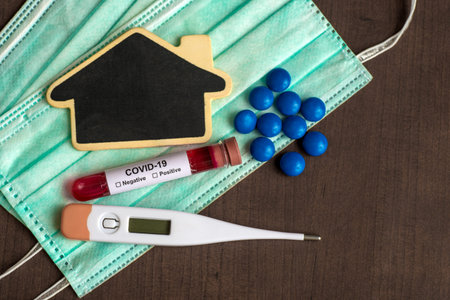 Test tube containing a blood sample for testing to the presence of coronavirus / COVID-19 with Mask,...