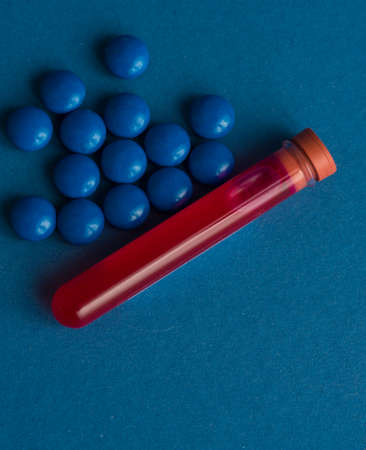A test tube filled with a blood sample for testing and pills tablets. virus pandemic epidemic concept.の写真素材