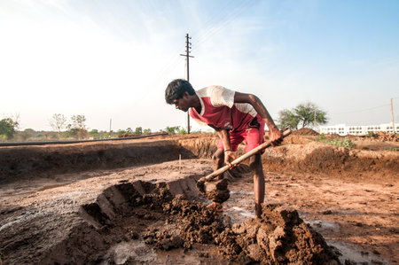 AMRAVATI, MAHARASHTRA - MAY 24, 2018: Unidentified Indian workers making bricks of clay by hand in the factory or field.のeditorial素材