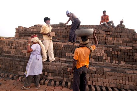 AMRAVATI, MAHARASHTRA - MAY 24, 2018: Unidentified Indian workers making bricks of clay by hand in the factory or field.のeditorial素材