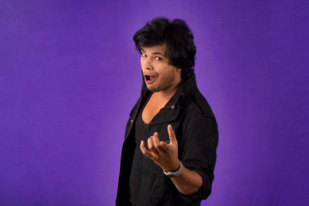 Young handsome man over dark background afraid and shocked with surprise and amazed expression, fear and excited face.の写真素材