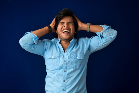 Young handsome man over dark background afraid and shocked with surprise and amazed expression, fear...