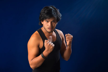 Portrait of a young man posing and showing his muscular body. The concept of a healthy lifestyle on...