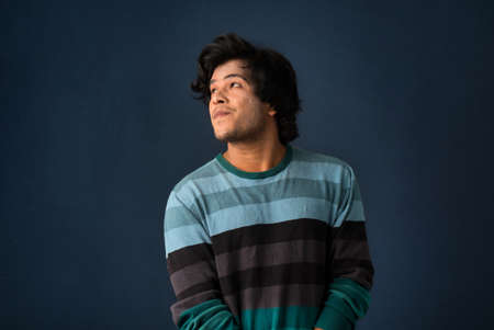 Portrait of a young man thinking on a dark backgroundの写真素材