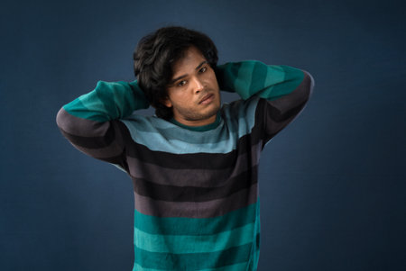 Portrait of a young man thinking on a dark backgroundの写真素材