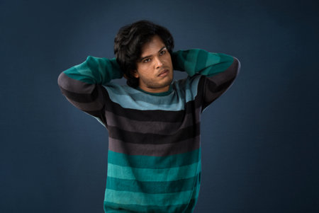 Portrait of a young man thinking on a dark backgroundの写真素材