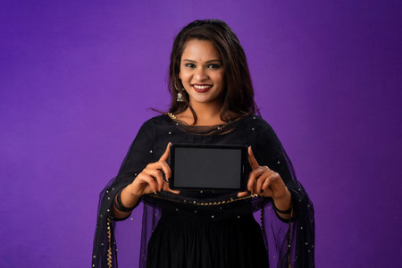 Young beautiful girl showing a blank screen of smartphone or mobile or tablet phoneの写真素材