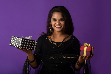 Portrait of young happy smiling woman or Girl holding gift box.の写真素材