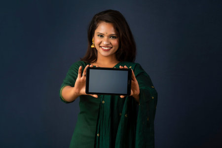 Young beautiful girl showing a blank screen of smartphone or mobile or tablet phone