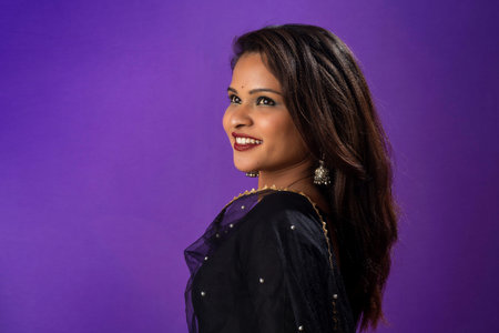 Portrait of a young girl or woman posing on purple backgroundの写真素材