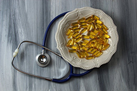 A plate of yellow capsules with a stethoscope.の写真素材