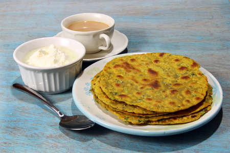 Methi Paratha,an Indian flatbread stuffed with fenugreek leaves and spices served in breakfast or brunch with tea and yogurt.の写真素材